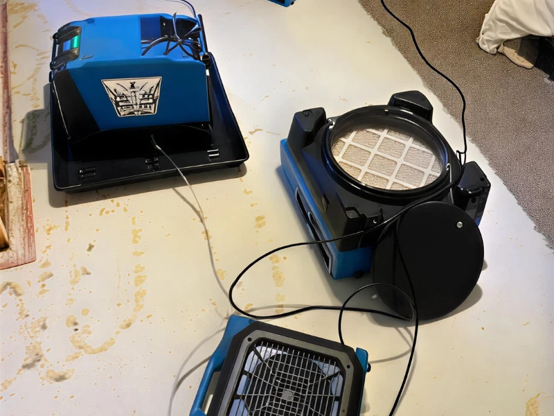 Disassembled blue and black air purifier parts on a white surface.